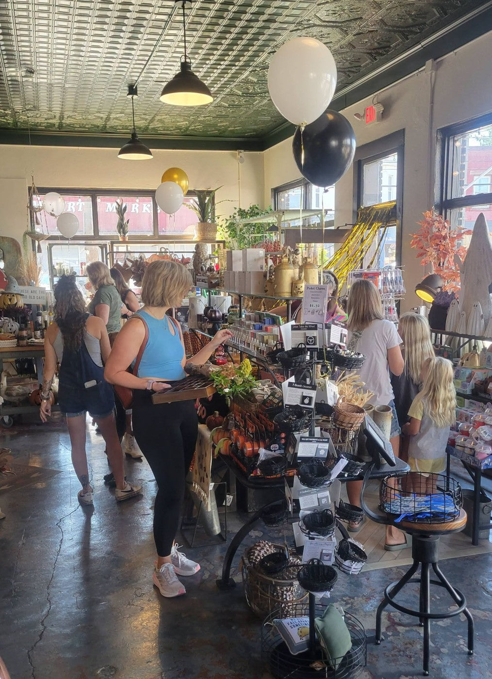 Visitors shopping inside Merchants On Main beneath the patterned ceiling